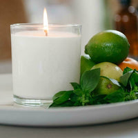 CandleXchange candle sitting on plate with mandarins, limes and basil